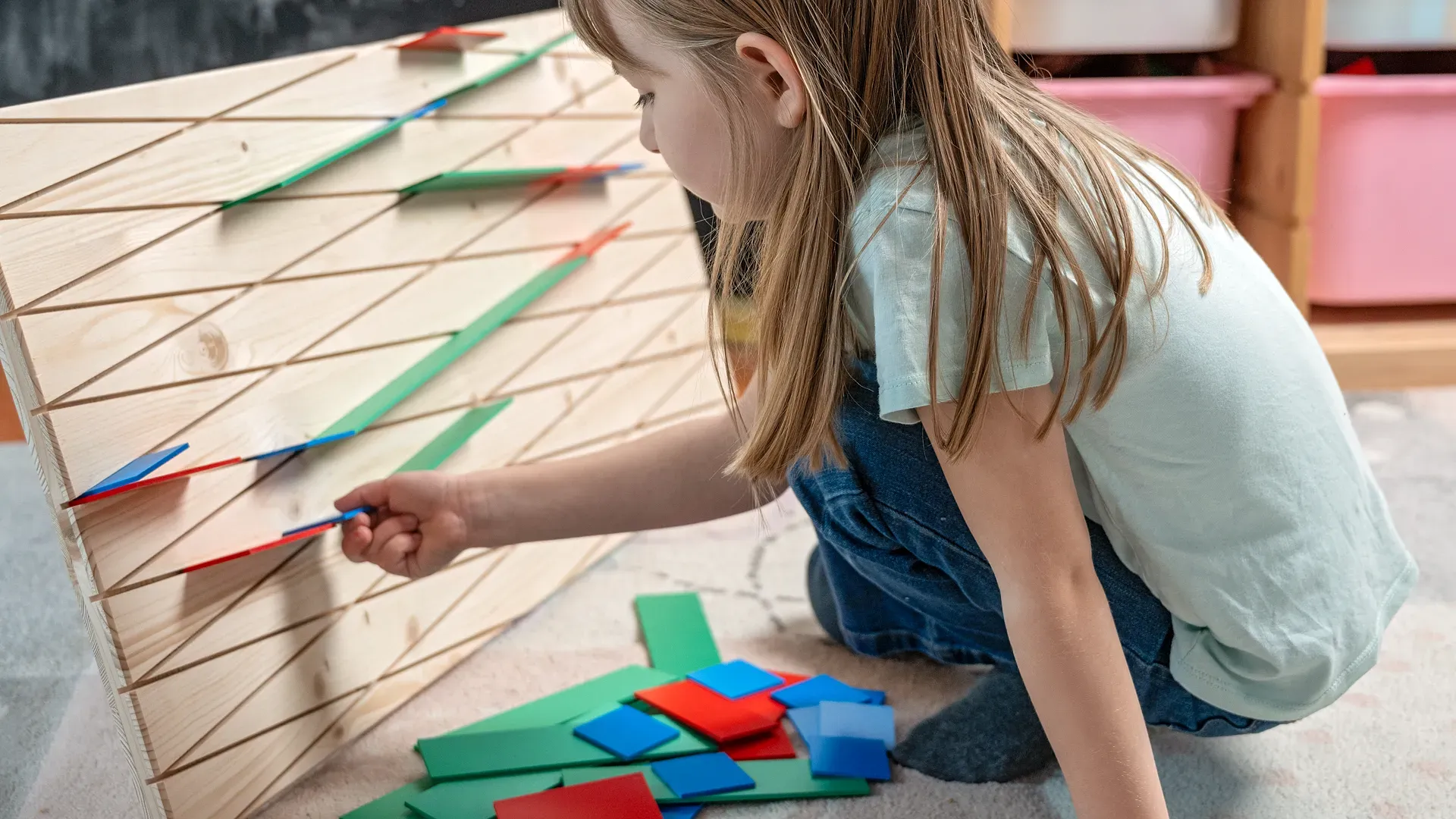A child is building a marble run using the Diagonalis marble run set